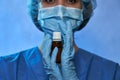 Doctor in medical gloves, mask and surgical cap with bottle with medicine closeup. Stop Coronavirus disease COVID-19, epidemic