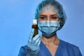 Doctor in medical gloves, mask and surgical cap with bottle with medicine closeup. Stop Coronavirus disease COVID-19, epidemic