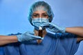 Doctor in medical gloves, mask and surgical cap with bottle with medicine closeup. Stop Coronavirus disease COVID-19, epidemic