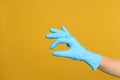 Doctor in medical gloves showing OK gesture on yellow background, closeup. Space for text Royalty Free Stock Photo