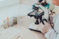 A doctor in a medical laboratory checking blood samples with a microscope