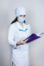 Doctor in medical mask looking paper on white background