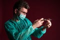 Doctor in medical mask make protective injection. Nurse in glasses prepare syringe.