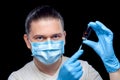 Doctor in a medical mask and sterile blue gloves holds in his hands a syringe. Royalty Free Stock Photo