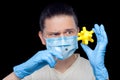A doctor in a medical mask and sterile blue gloves holds a syringe. Royalty Free Stock Photo