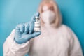 Doctor in medical PPE suit with Coronavirus vaccine vial. Doctor preparing a dose for a patient of the third vaccine for Royalty Free Stock Photo