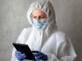 Doctor in medical PPE suit uses digital tablet Royalty Free Stock Photo