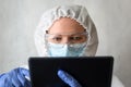 Doctor in medical PPE suit uses digital tablet Royalty Free Stock Photo