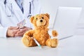 Doctor medicating teddy bear in paediatric concept