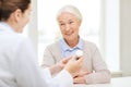 Doctor with medicine and senior woman at hospital Royalty Free Stock Photo