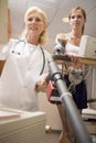 Doctor Monitoring Female Patient On Treadmill