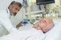 Doctor monitoring patient wearing oxygen mask