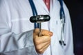 A doctor or neurologist holds a rubber reflex hammer in his hand, demonstrating it to the camera, preparing to conduct a physical