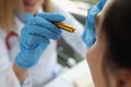 Doctor neurologist shining flashlight on patient eyes in clinic closeup