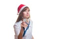 The doctor in a New Year's cap listens a stethoscope