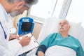 Doctor noting hospital patients blood pressure reading Royalty Free Stock Photo