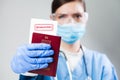 Doctor or nurse at airport customs security check holding a passport