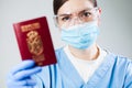 Doctor or nurse at airport customs security check holding a passport