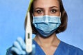 Doctor with blurred thermometer in hand in mask and medical gloves,  on studio background. Coronavirus COVID-19 Royalty Free Stock Photo