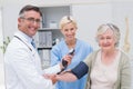 Doctor and nurse checking patients blood pressure Royalty Free Stock Photo