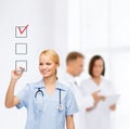 Doctor or nurse drawing checkmark into checkbox Royalty Free Stock Photo