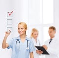 Doctor or nurse drawing checkmark into checkbox Royalty Free Stock Photo