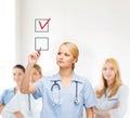 Doctor or nurse drawning checkmark into checkbox Royalty Free Stock Photo