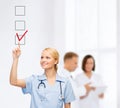 Doctor or nurse drawning checkmark into checkbox Royalty Free Stock Photo