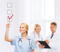 Doctor or nurse drawning checkmark into checkbox Royalty Free Stock Photo