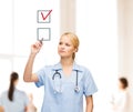 Doctor or nurse drawning checkmark into checkbox Royalty Free Stock Photo