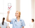 Doctor or nurse drawning checkmark into checkbox Royalty Free Stock Photo