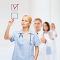 Doctor or nurse drawning checkmark into checkbox Royalty Free Stock Photo