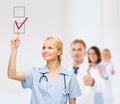 Doctor or nurse drawning checkmark into checkbox Royalty Free Stock Photo