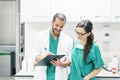 Doctor and nurse examining report of patient