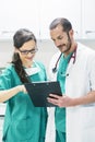 Doctor and nurse examining report of patient