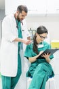 Doctor and nurse examining report of patient