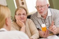 Doctor or Nurse Explaining Prescription Medicine to Senior Couple Royalty Free Stock Photo