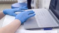 Doctor or nurse hands in blue nitrile medical gloves typing on Laptop computer keyboard in hospital Royalty Free Stock Photo