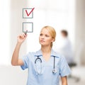 Doctor or nurse with marker drawning red checkmark Royalty Free Stock Photo