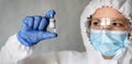 Doctor or nurse in medical PPE suit holding COVID-19 coronavirus vaccine Royalty Free Stock Photo