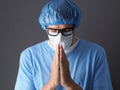 The Doctor or Nurse is Praying to God requesting that the coronavirus covid-19 not spread.