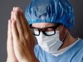 The Doctor or Nurse is Praying to God requesting that the coronavirus covid-19 not spread.