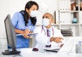 Doctor and nurse in protective medical mask check patient data in hospital computer Royalty Free Stock Photo