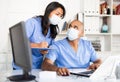 Doctor and nurse in protective medical mask check patient data in hospital computer Royalty Free Stock Photo