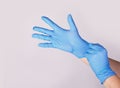 Doctor or nurse putting on blue nitrile surgical gloves, professional medical safety and hygiene Royalty Free Stock Photo