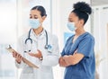 Doctor and nurse reading medical information paperwork with mask for safety from covid or corona virus in a hospital Royalty Free Stock Photo