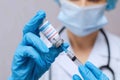 Doctor, nurse, scientist hand in blue gloves holding coronavirus, covid-19 vaccine and syring Royalty Free Stock Photo