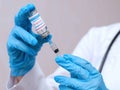 Doctor, nurse, scientist hand in blue gloves holding coronavirus, covid-19 vaccine and syring Royalty Free Stock Photo