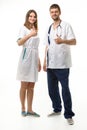 Doctor and nurse show hand gesture thumbs up and look happily into frame