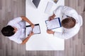 Doctor And Nurse Sitting Face To Face Having Meeting